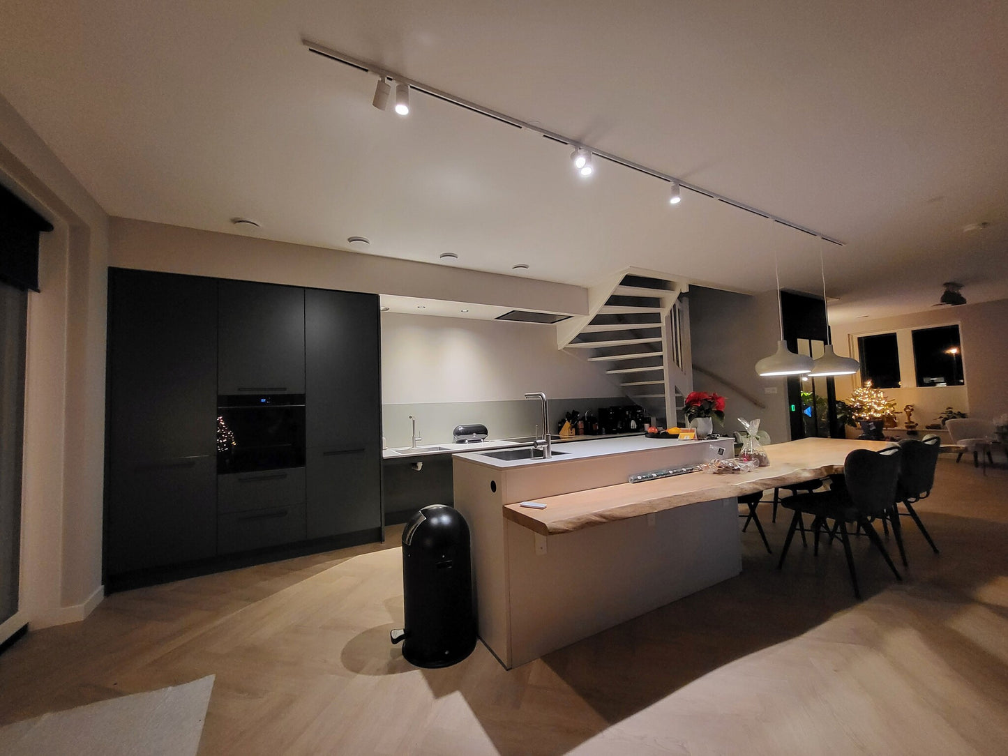 witte 1-fase railverlichting met spot en hanglampen boven een kookeiland