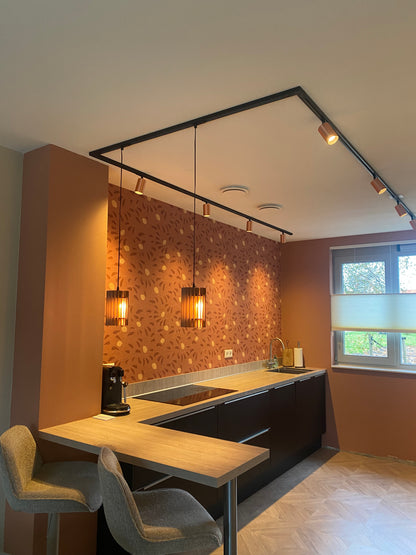 Klantfoto met roze houten hanglampen boven een eiland