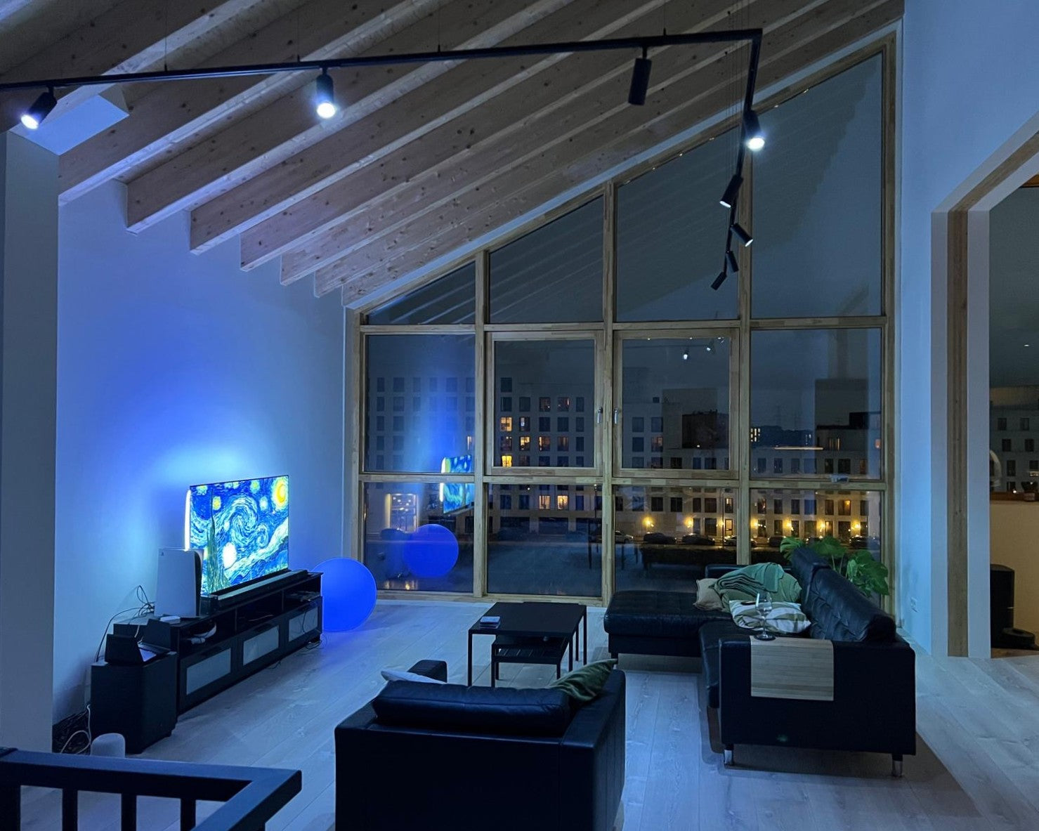 Railverlichting in woonkamer aan staaldraad met GU10 spots met Hue lampen die gekleurd licht geven