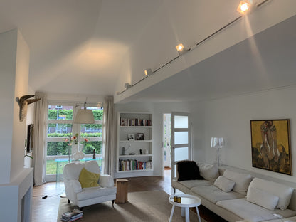 Witte 1-fase railverlichting met KUBY GU10 spots gemonteerd aan de wand in een woonruimte.