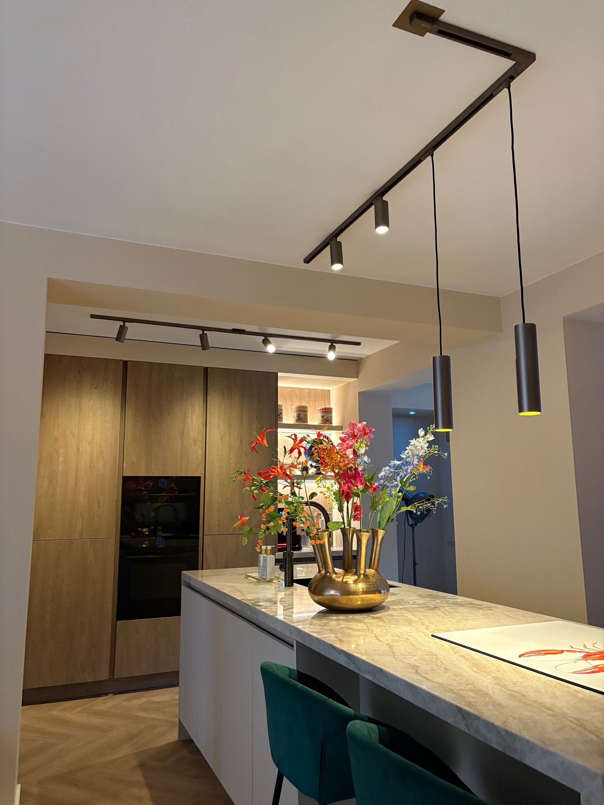 bronskleurige GU10 railspot met bronzen pendels in de keuken