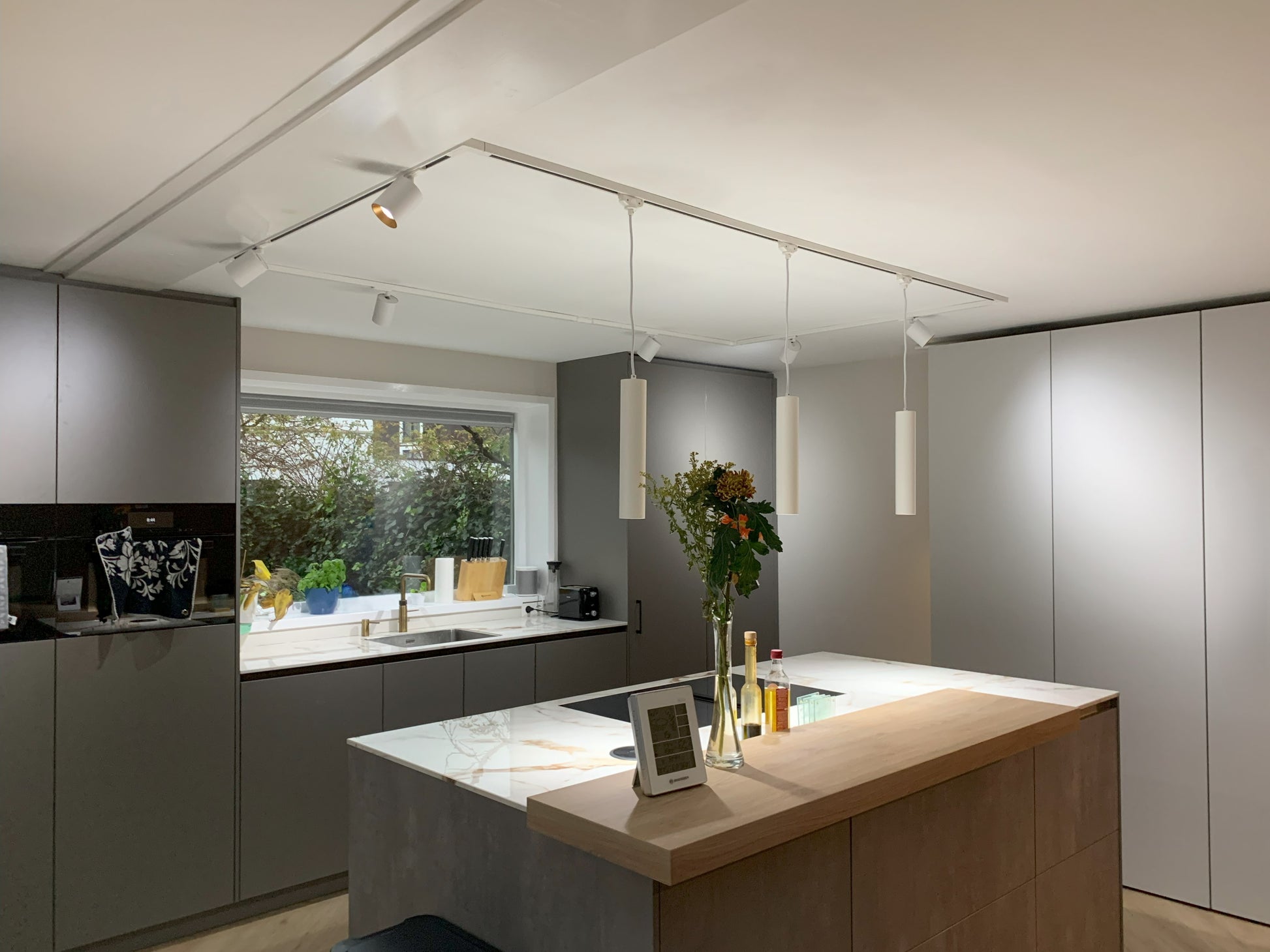 strakke 1-fase railverlichting met witte spots en pendel hanglampen voor keukenverlichting