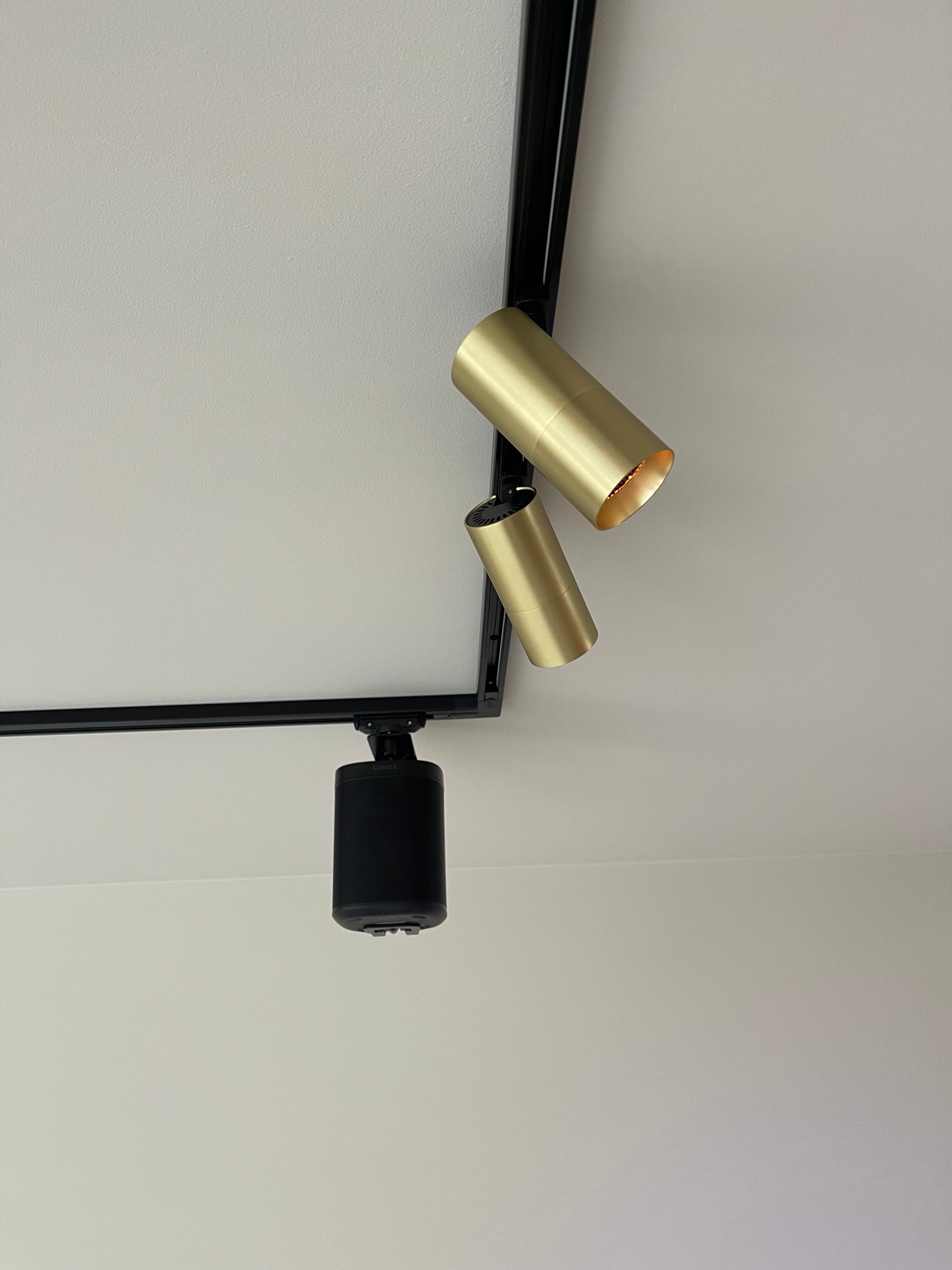railverlichting met gouden railspots en sonos speakers